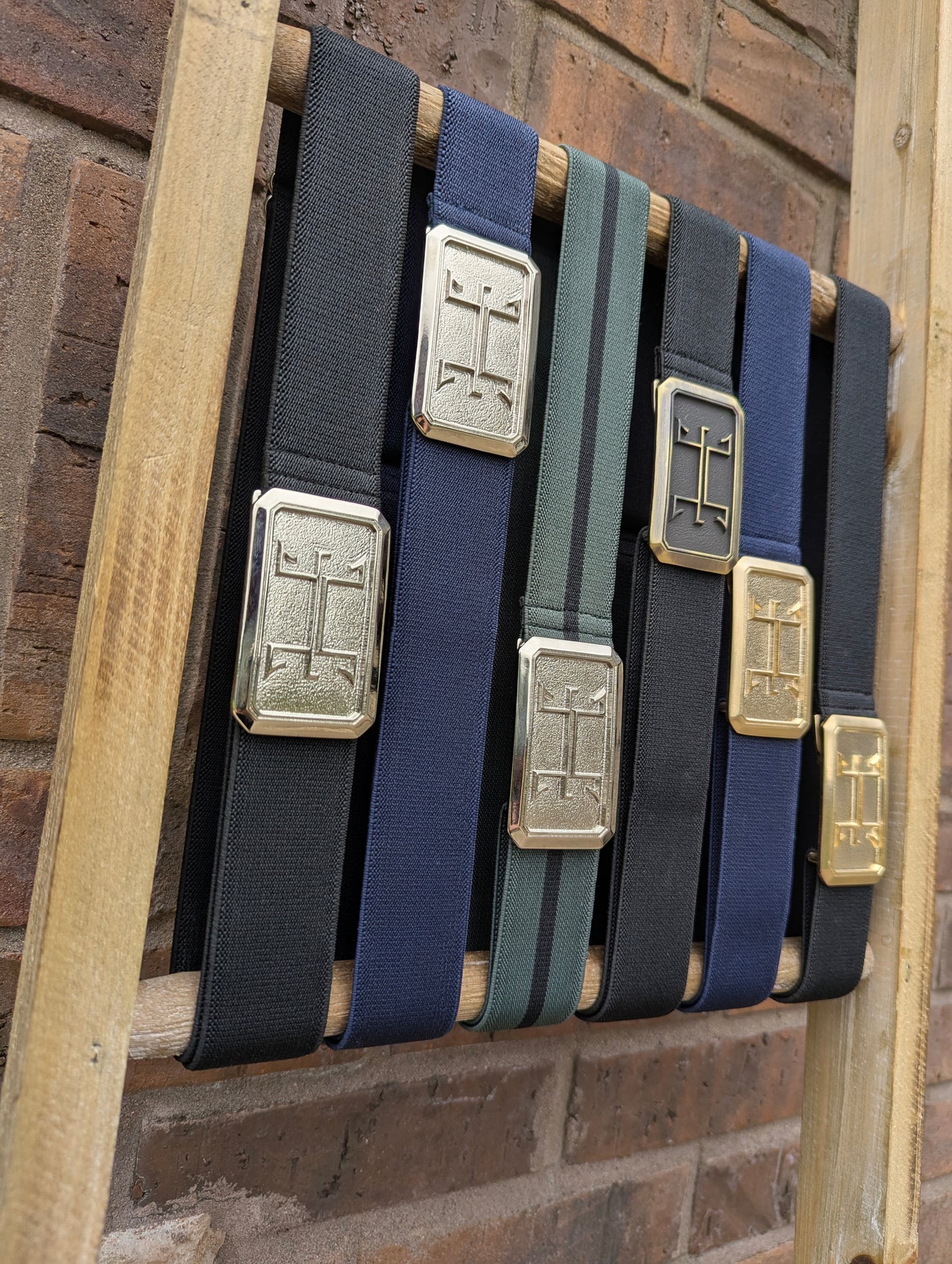 huston ellany signature belt collection displayed on a ladder next to a brick wall