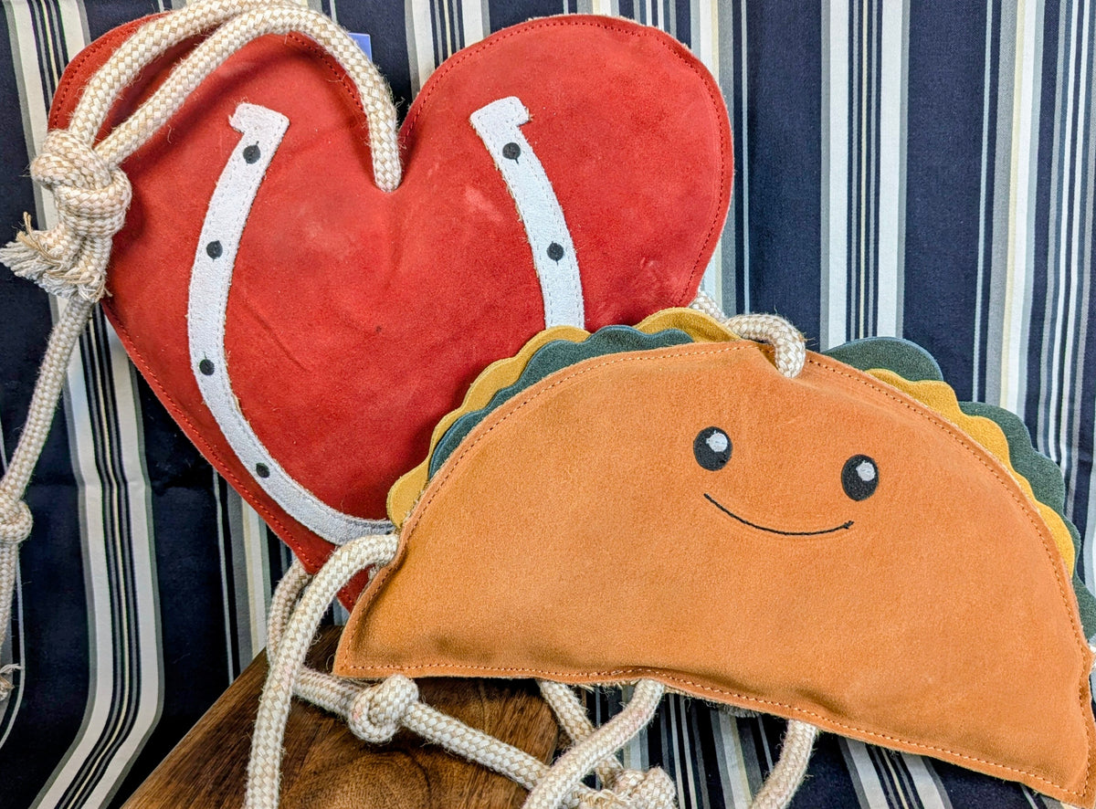 Heart-shaped and taco-shaped horse stall toys with a striped background.