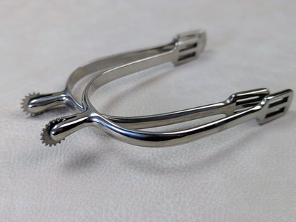 silver english spurs with small rowel on a textured grey table