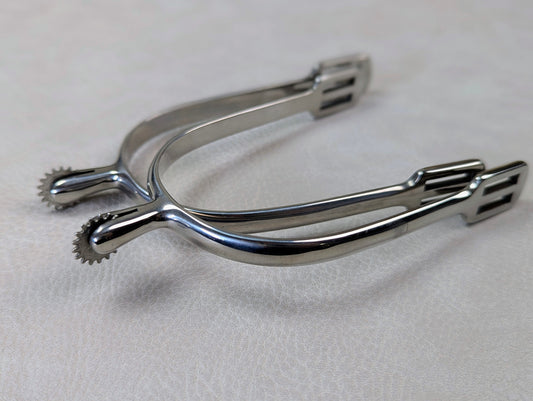silver english spurs with small rowel on a textured grey table