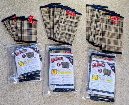 Three packages of BAKER fly boots in sizes S, M, and L, arranged alongside loose stacks of the same product on a beige carpet background.