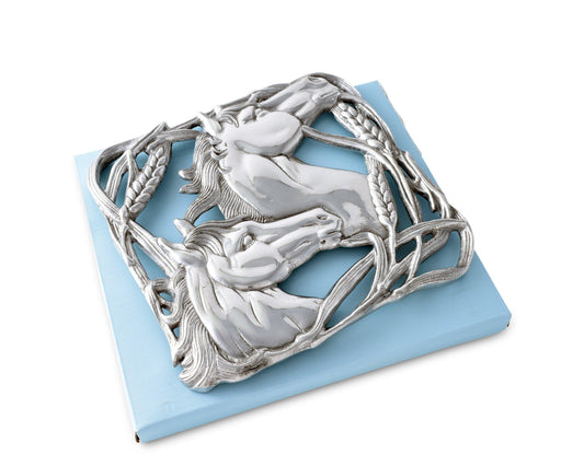 Cast aluminum trivet featuring two sculpted horse heads facing opposite directions, surrounded by an ornate border of intertwined wheat stalks
