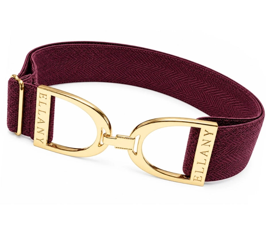 Fig‑burgundy herringbone elastic belt with polished gold Ellany stirrup buckle, displayed as a modern fall accessory.
