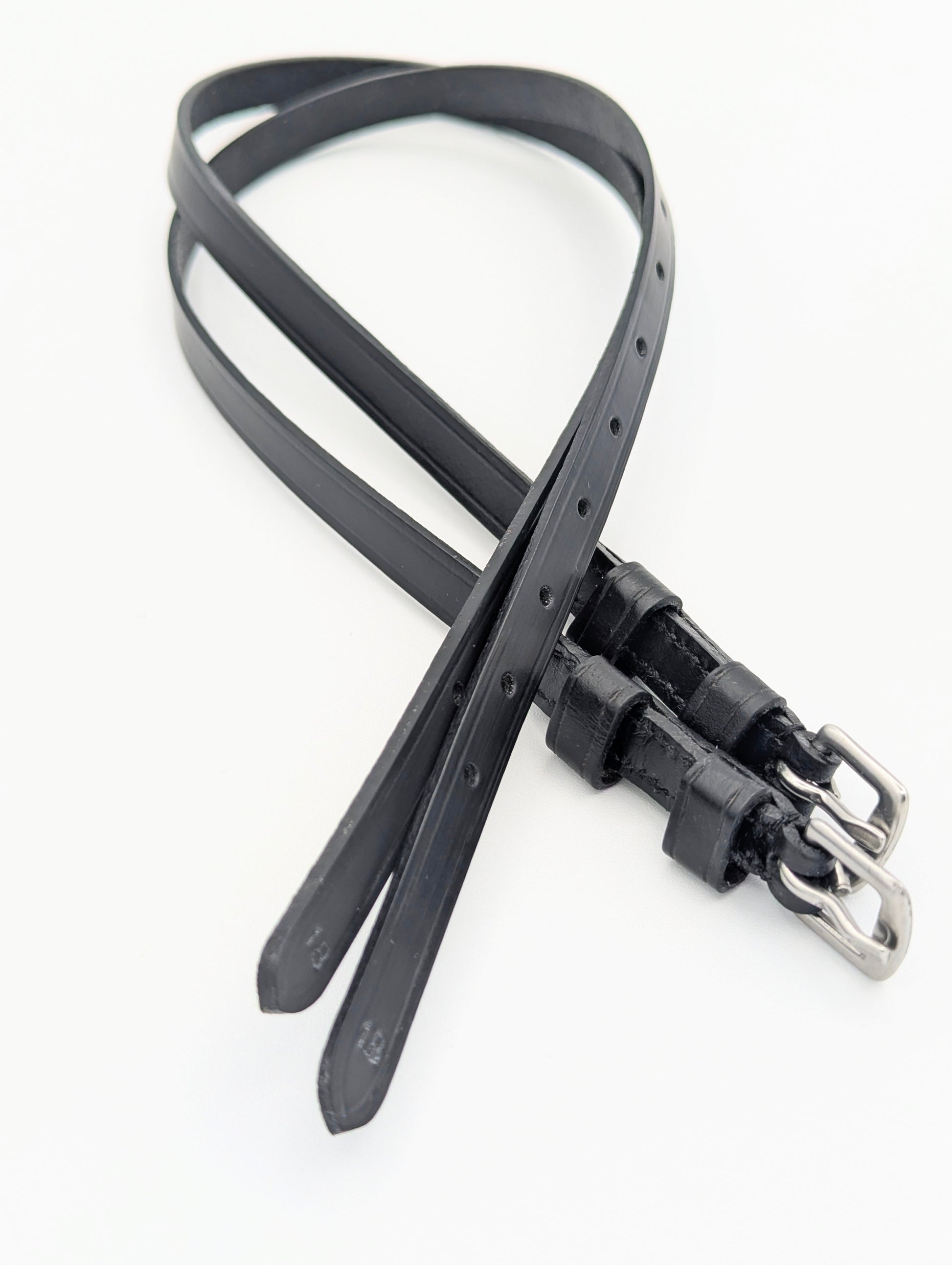 Black leather spur straps with square stainless steel buckles, shown laid out to display stitching, adjustment holes, and double keepers.