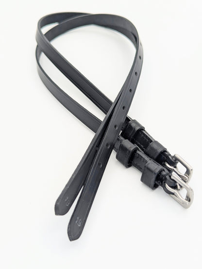 Black leather spur straps with square stainless steel buckles, shown laid out to display stitching, adjustment holes, and double keepers.
