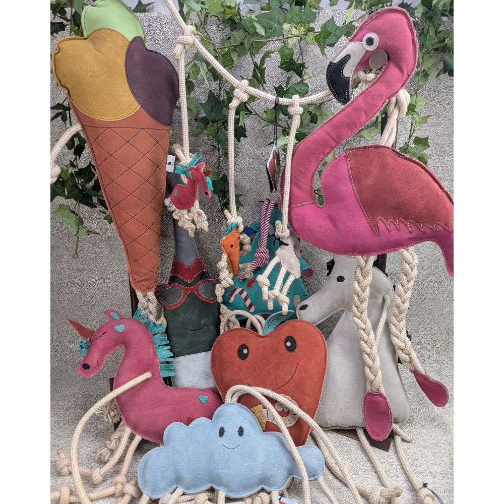 Assorted horse stall toys flamingo, ice cream cone, heart, unicorn and blue cloud on an ivy background.