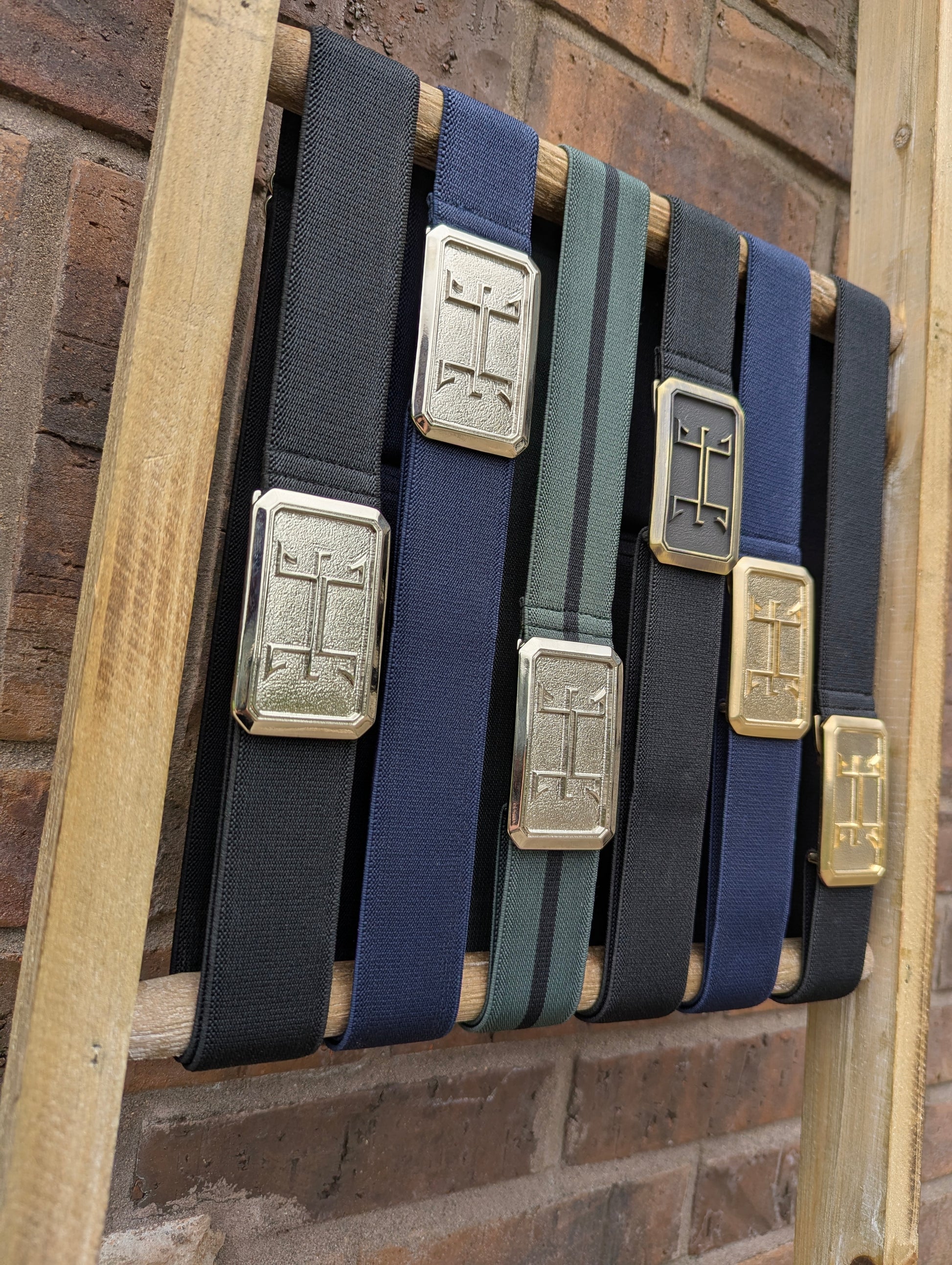 huston ellany signature belt collection displayed on a ladder next to a brick wall