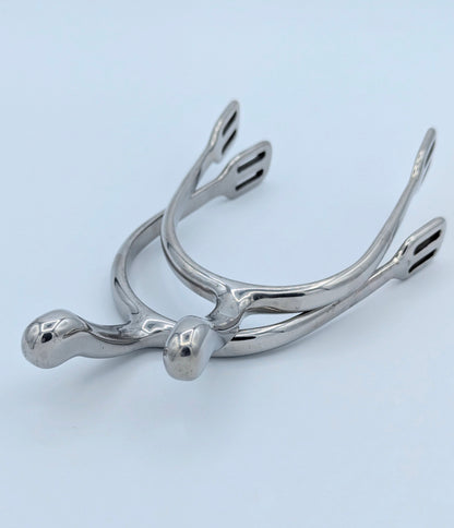 Pair of stainless steel swan‑neck spurs displayed on a light background, showing the curved neck and strap slots.