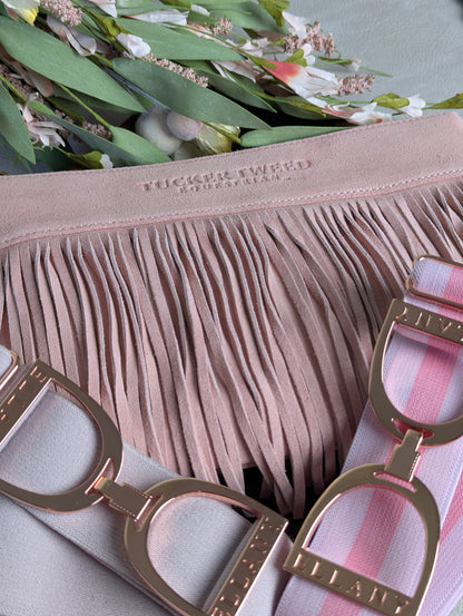 A close-up of a light pink fringed clutch with two matching ELLANY belt options