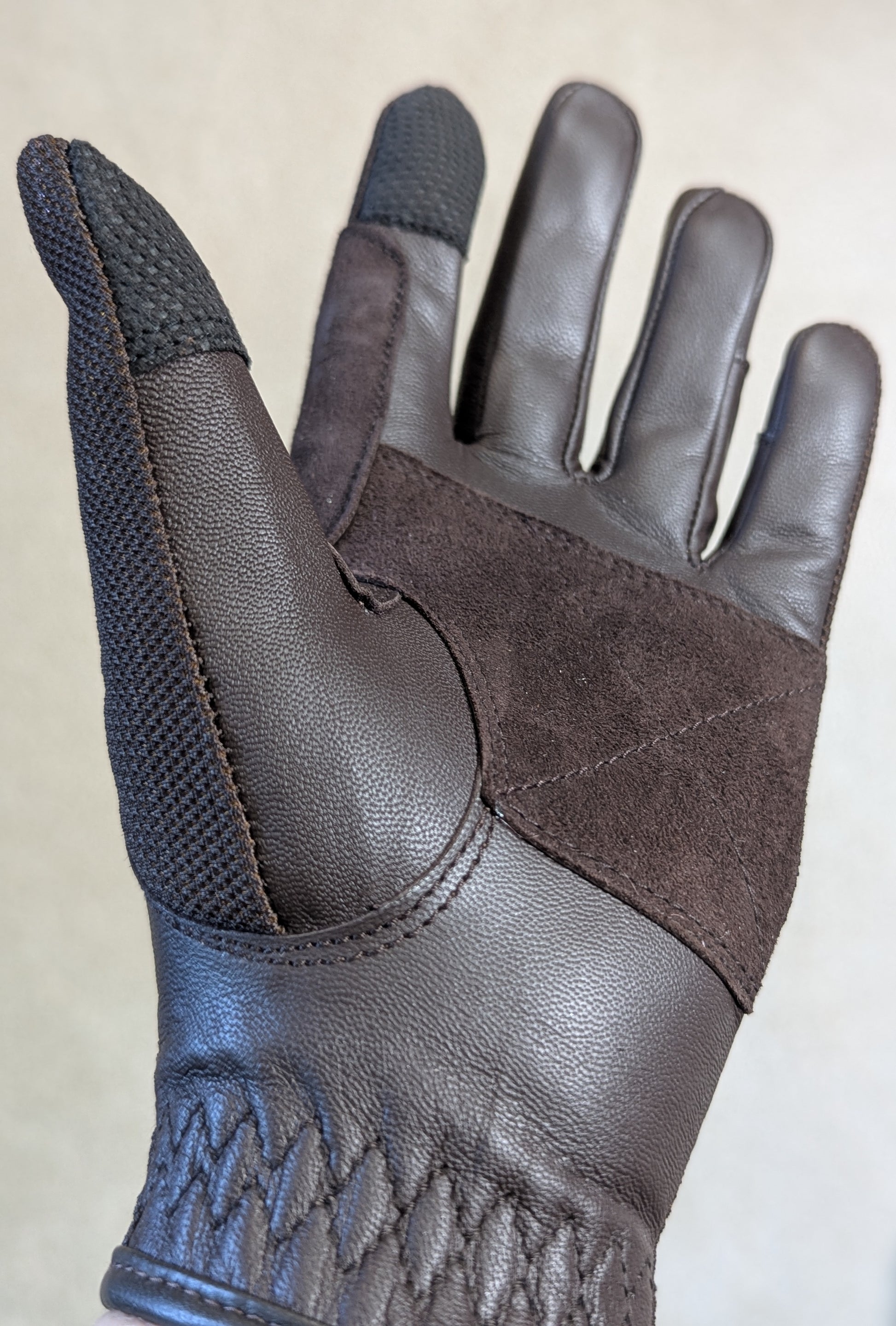 Tobacco leather riding glove with brown  suede accents on a light gray background