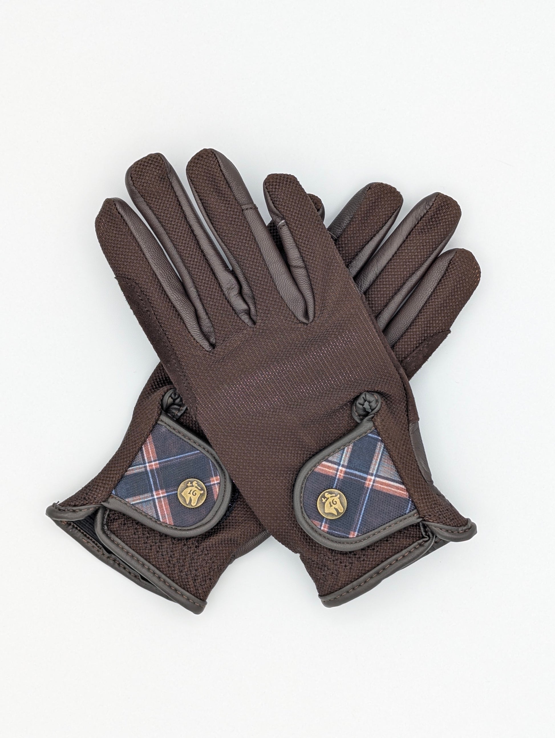 Brown tobacco riding gloves made of breathable mesh and smooth leather, featuring a small Field Plaid wrist tab with a metal button and elastic gathered cuff.