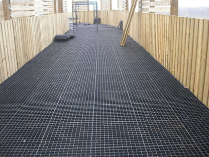 Stall Grid equine flooring used as the foundation layer in a horse walker lane, providing drainage and structural support.
