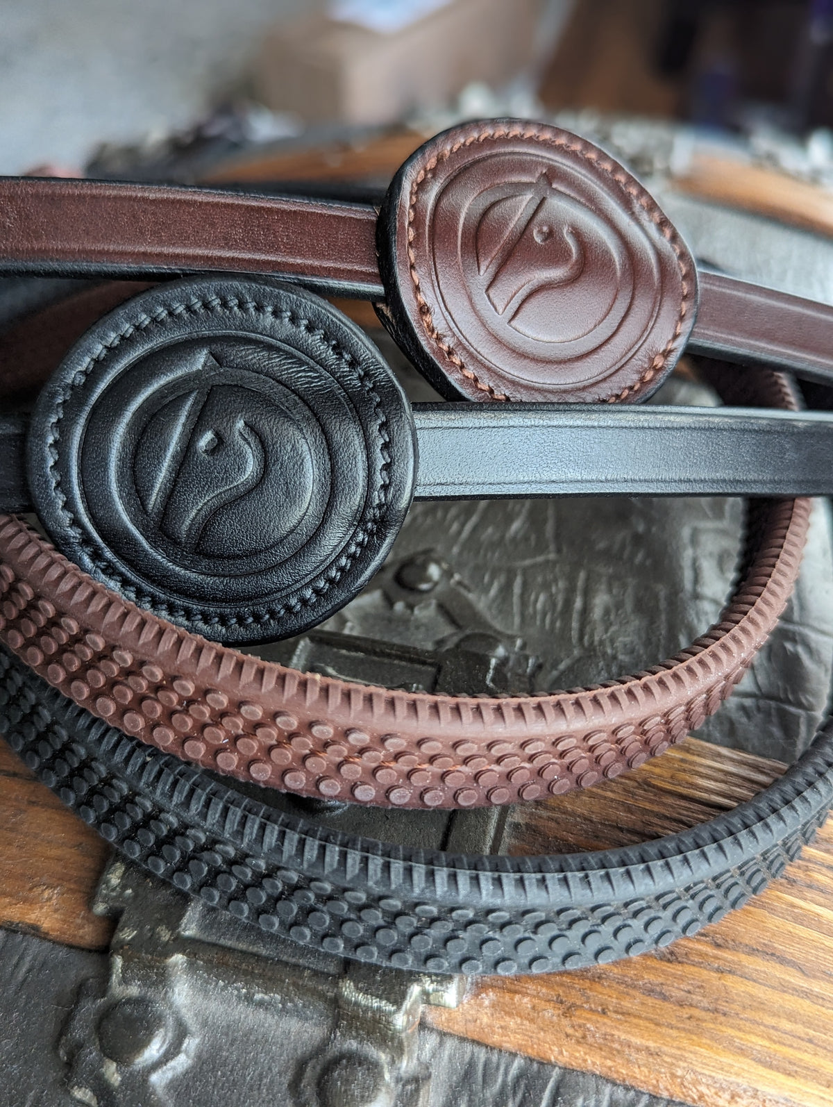 Black and brown trust samorin rubber reins on a wodden and metal background.