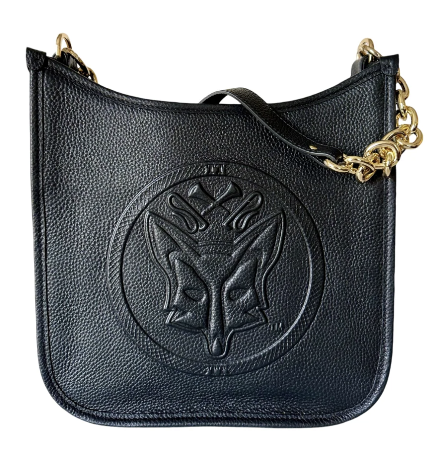 Black Tucker Tweed Middleburg Messenger purse shown upright on a neutral background, featuring the embossed equestrian emblem on the front, gold chain strap, and textured pebble‑grain leather.