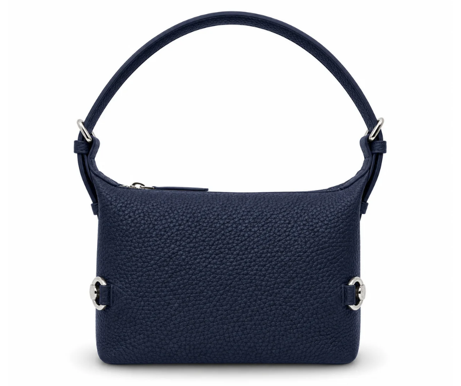 Navy Tucker Tweed Bethany Bit Bag in pebbled Togo leather with a structured silhouette, silver hardware, and top zipper, shown standing upright against a neutral background.