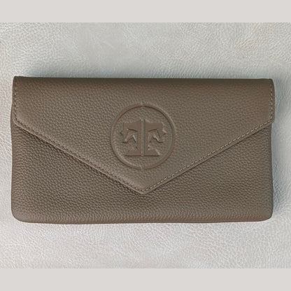 A stone brown grey tuape pebbled leather envelope belt bag with a circular embossed logo featuring a balance scale, displayed on a light gray textured background.