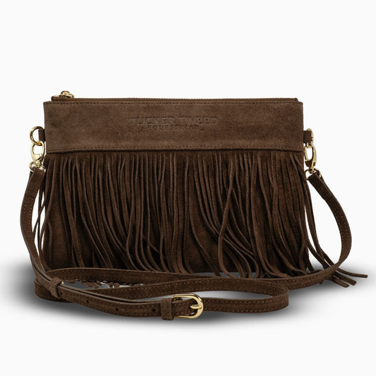 A brown suede crossbody clutch bag with a long fringe front, gold-tone hardware, and a matching adjustable shoulder strap, shown on a light gray background.