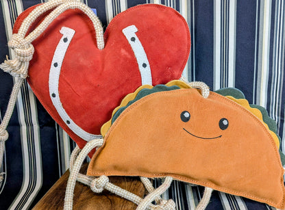 Heart-shaped and taco-shaped horse stall toys with a striped background.